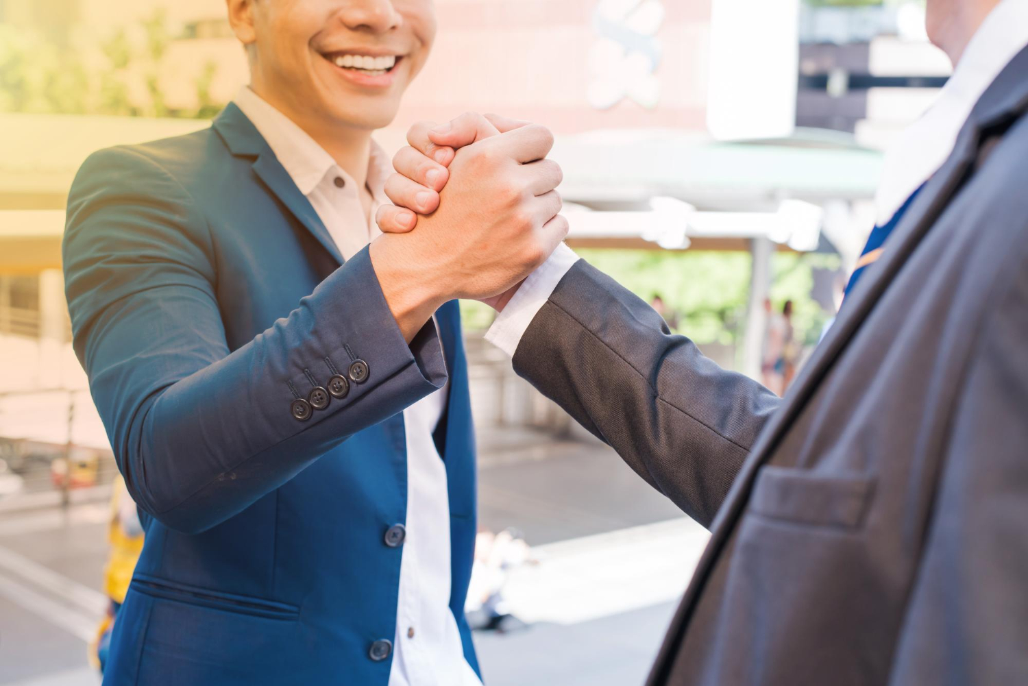 Estrategias para la nutrición de leads en B2B 1 Dos hombres de negocios estrechándose las manos en señal de acuerdo, representando acuerdos gracias a la nutrición de leads en B2B.