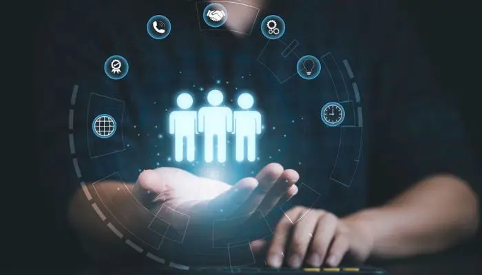 Blog 1 Iconos de tres personas en la palma de una mano rodeados de iconos tecnológicos